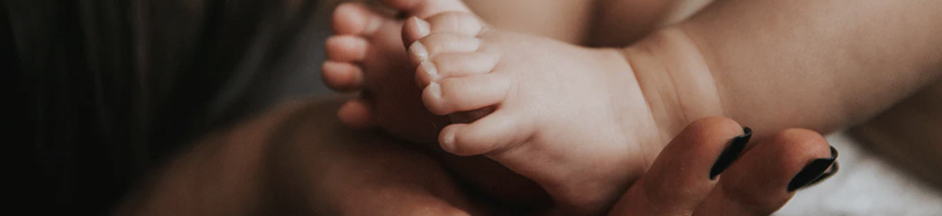 Image of mom's hand and baby's feet banner